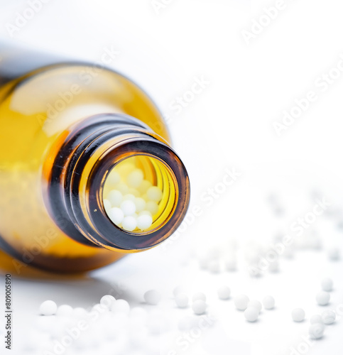 Homöopathische Globuli in einem glasfläschen isoliert auf weissem hintergrund