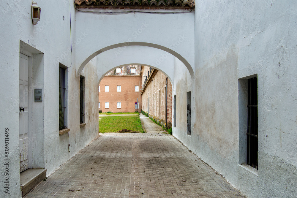 Obraz premium passage with windows, door and arch leading to an interior courtyard with buildings