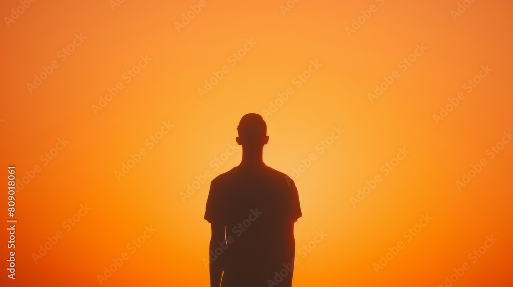 Silhouette of a man against a vivid orange sunset