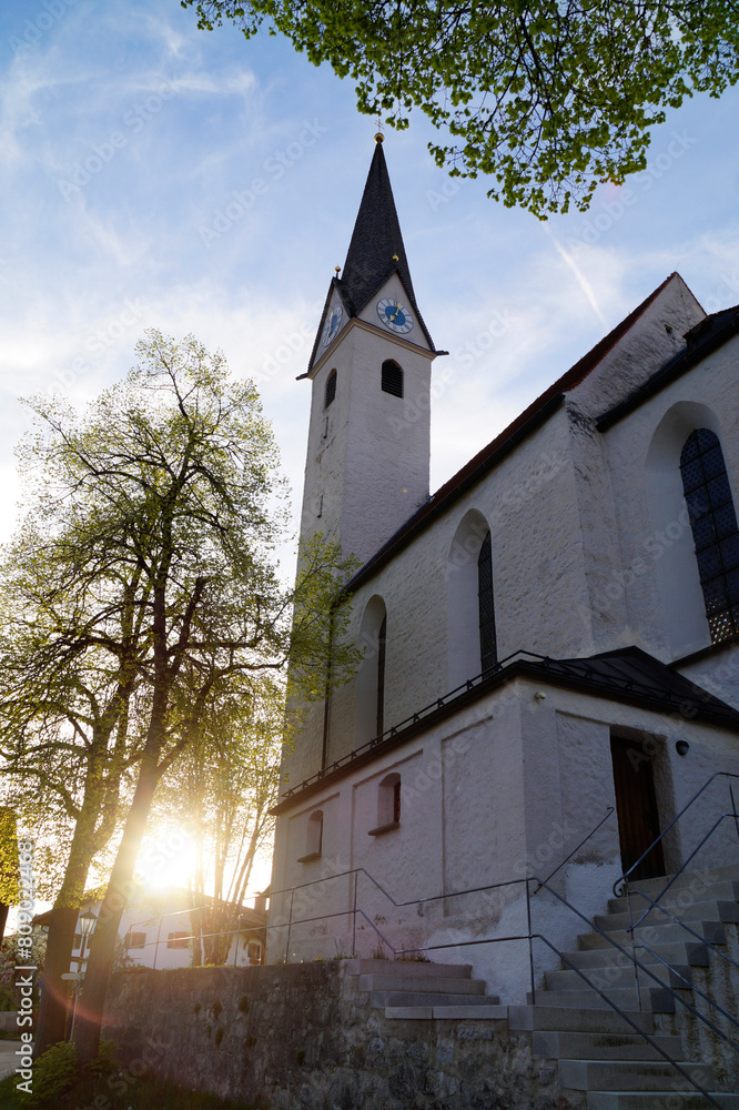 an old church against the sunlight in the alpine village Schwangau in the Bavarian Alps on a spring evening (Allgaeu, Bavaria, Germany) an old church against the sunlight in the alpine village Schwangau in the Bavarian Alps on a spring evening (Allgaeu, Bavaria, Germany)