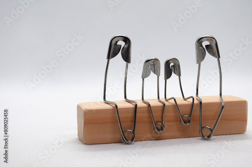 Model safety pin of family sitting on wooden block with customizable space for text