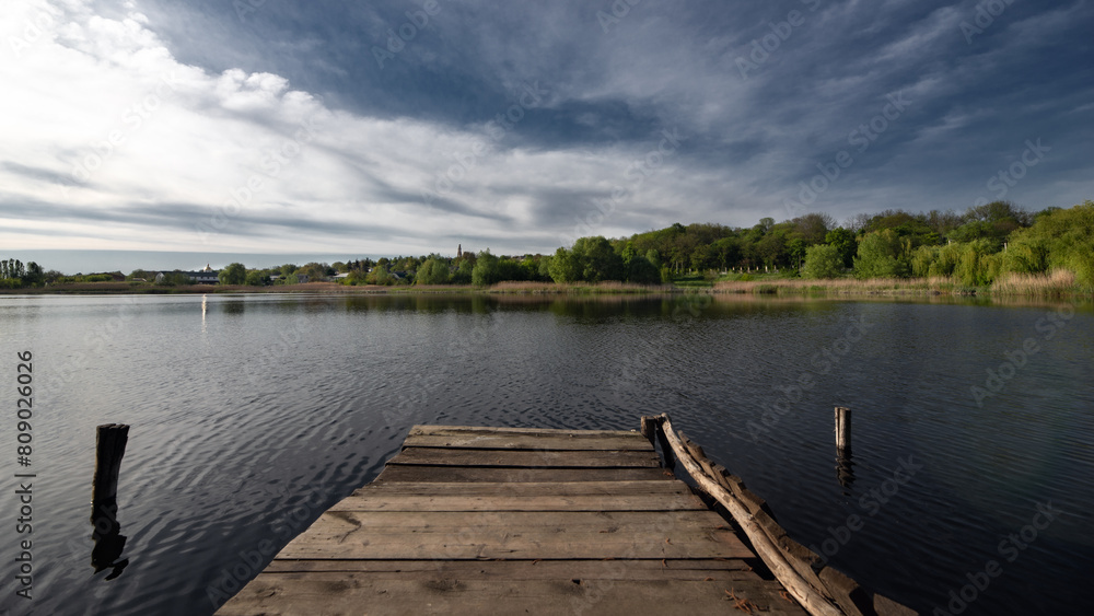 Fishing grounds. Inland reservoir. Wooden fishing bridge. Village landscape. Lake in the countryside. Fishing grounds. Inland reservoir. Wooden fishing bridge. Village landscape. Lake in the countryside.