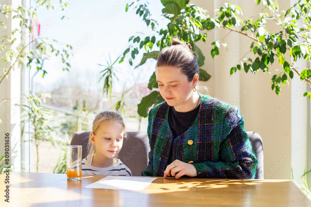 Mother and Daughter Reviewing Menu Together at Sunlit Table Surrounded by Indoor Plants Mother and Daughter Reviewing Menu Together at Sunlit Table Surrounded by Indoor Plants