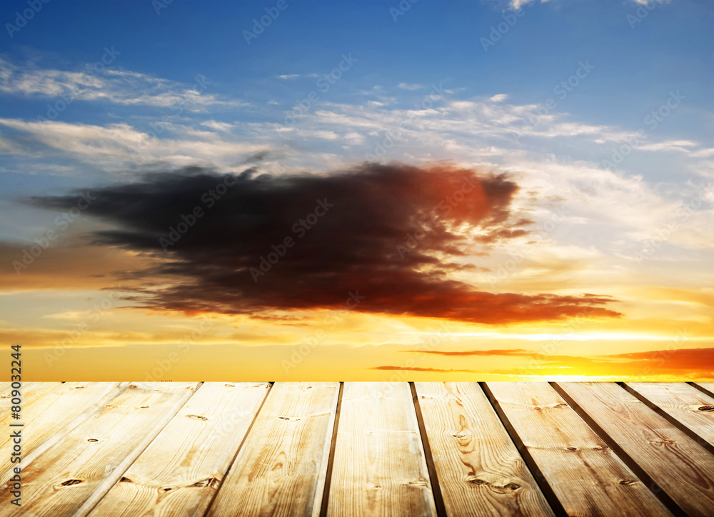 Wooden table on sky background and sunset light	