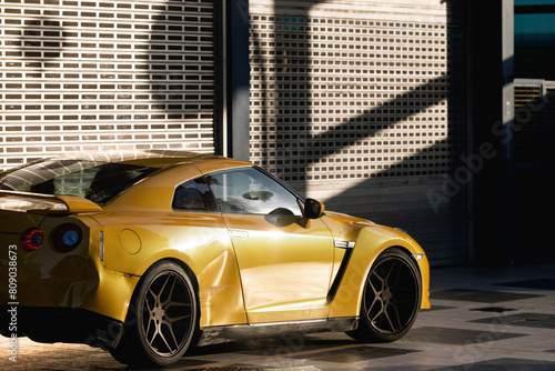 A crumpled orange sports car in the sunset-lit sunlight after a traffic accident.rushed parts