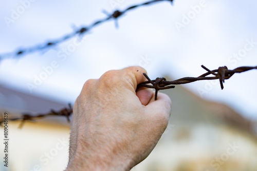 Hand and barbed wire. Violation of the law on the departure of citizens from Ukraine