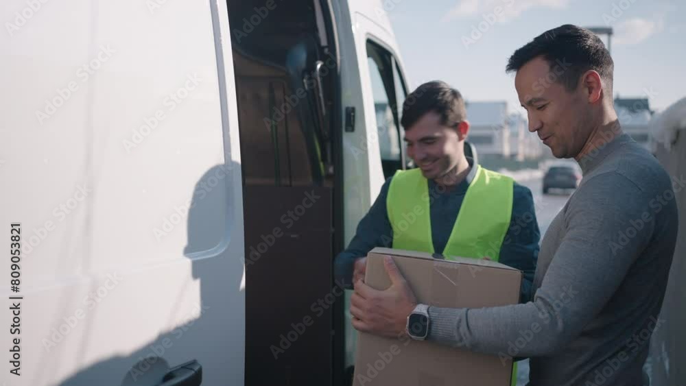 Man walking up to the delivery man who hands him his package. Man singing paper Man walking up to the delivery man who hands him his package. Man singing paper