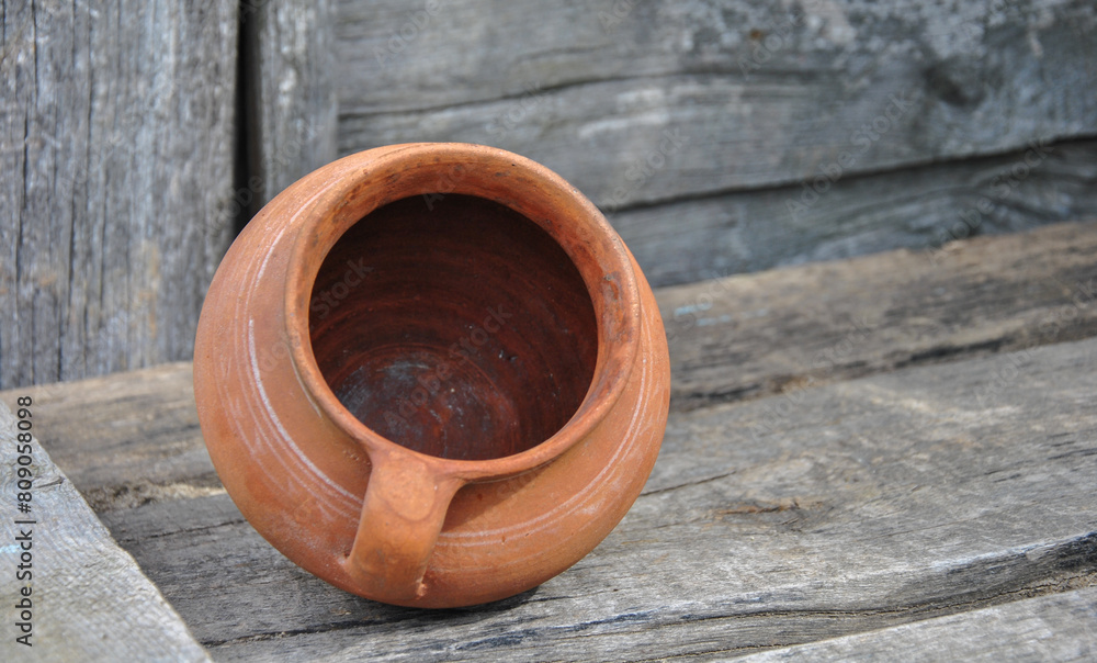 clay old pot on a wooden old table. background blur. clay dishes