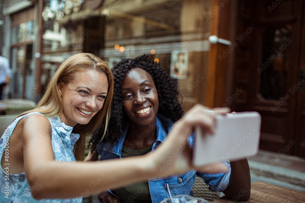 Two young women taking selfie in street cafe Two young women taking selfie in street cafe