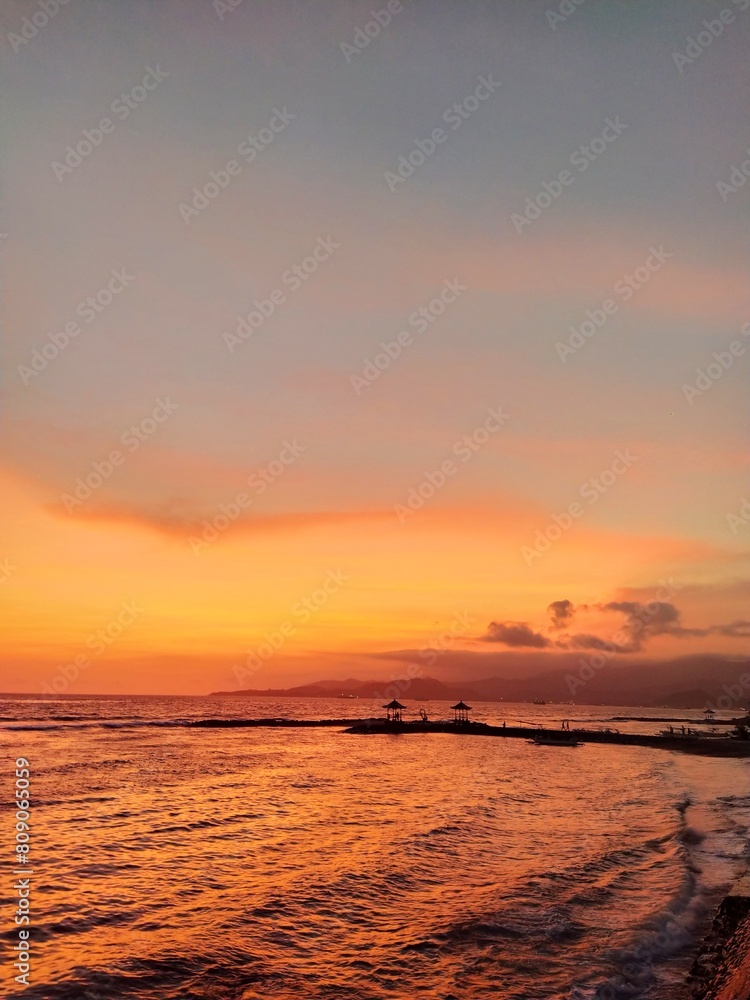Golden sunset on the island of Bali, ocean shore, sky, surf, clouds, sandy beach