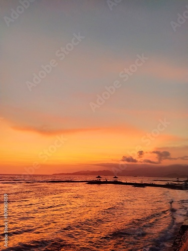 Golden sunset on the island of Bali  ocean shore  sky  surf  clouds  sandy beach