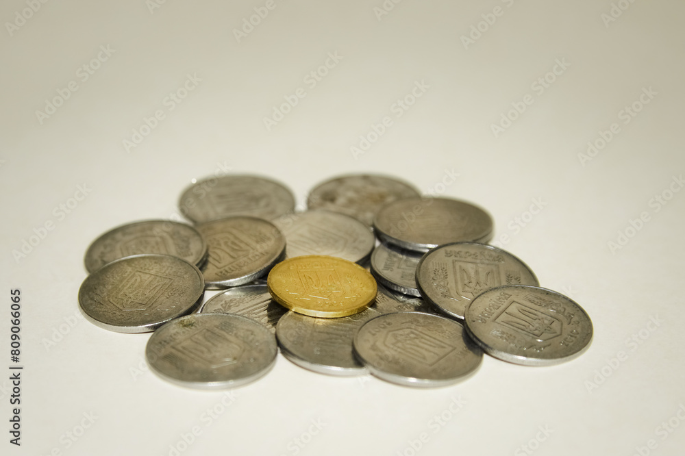Ukrainian coins with the Ukrainian coat of arms close-up, one gold coin against the background of silver coins with the Ukrainian coat of arms, Ukrainian currenc Ukrainian coins with the Ukrainian coat of arms close-up, one gold coin against the background of silver coins with the Ukrainian coat of arms, Ukrainian currenc