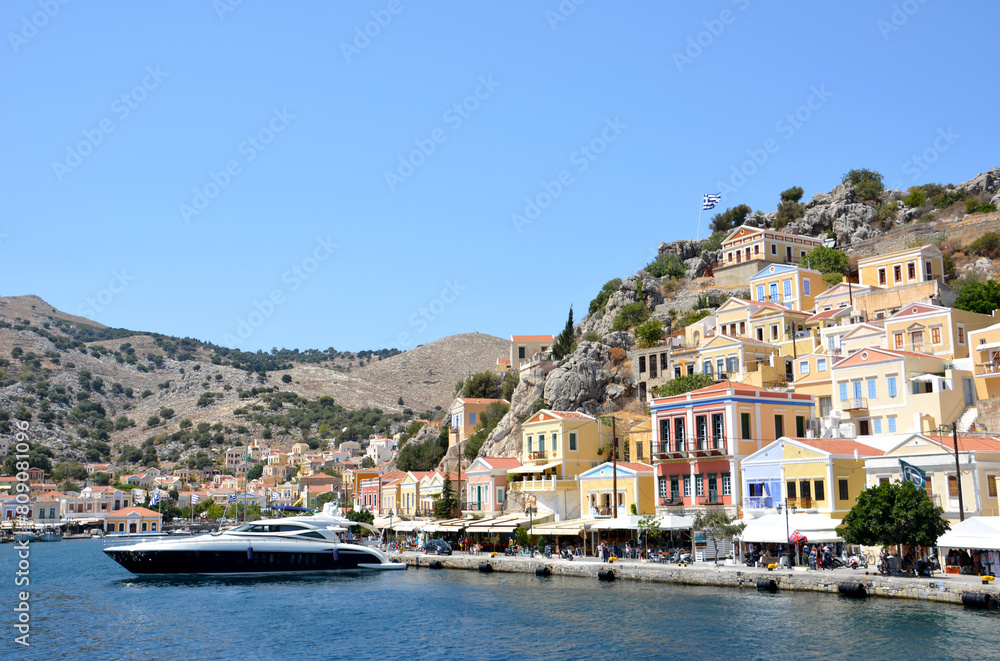 a boat is in front of multicolored buildings greek island copy space