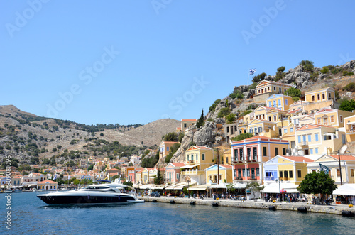 a boat is in front of multicolored buildings greek island copy space