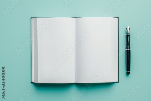Mockup of an open classic hardcover notebook with a fountain pen on teal blue background photo