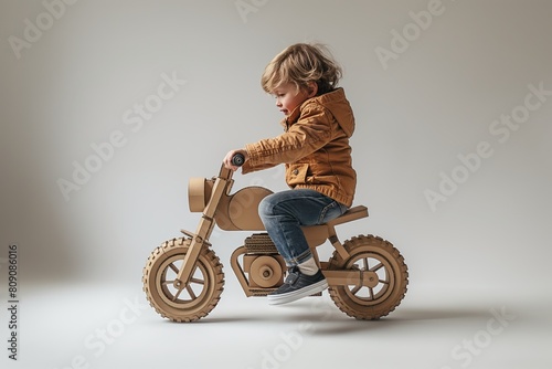 Young child riding a cardboard motorcycle photo