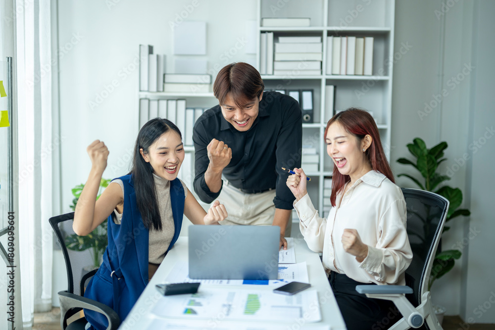 Three people are celebrating in a cubicle with a laptop on the table. Scene is happy and positive Three people are celebrating in a cubicle with a laptop on the table. Scene is happy and positive