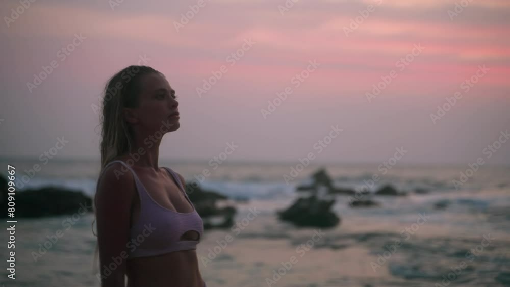 Graceful woman in bikini strolls along sandy shore, pastel sunset light bathes tranquil sea. Serene walk, reflective mood, ocean waves gently break. Solo traveler enjoys beach, embraces summer vibes. Graceful woman in bikini strolls along sandy shore, pastel sunset light bathes tranquil sea. Serene walk, reflective mood, ocean waves gently break. Solo traveler enjoys beach, embraces summer vibes.