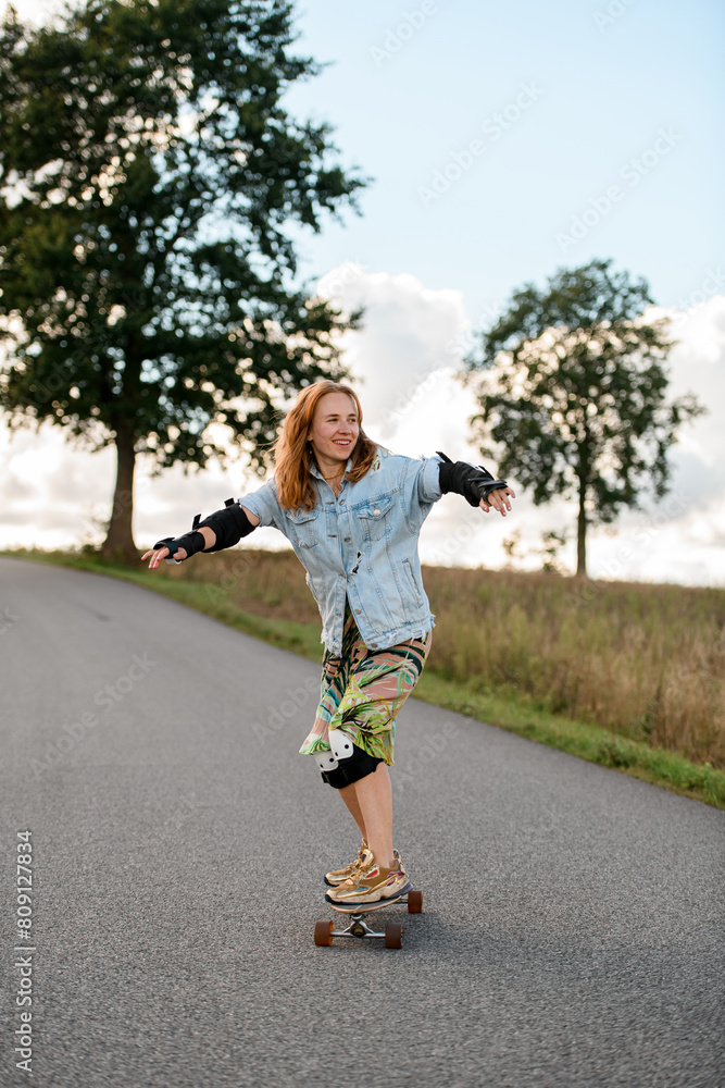 Country road laughter. Young, beautiful girl rides a longboard. Country road laughter. Young, beautiful girl rides a longboard.