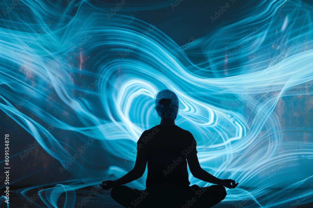 A woman sits in a lotus position in front of a blue background