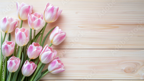 Elegant pink and white tulips arranged on a natural light wooden background with space for text  perfect for spring themes