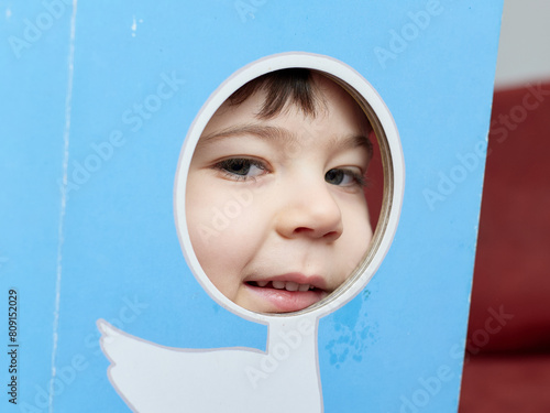 cute baby boy playing with card board cutouts of various animals photo