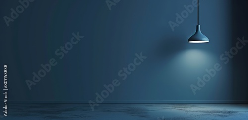 A minimalist image showing a blue room with a hanging pendant light creating a glow on the wall
