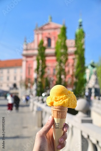 Hand Holding Orange Ice Cream Cone at Old Town of Ljubljana in Slovenia