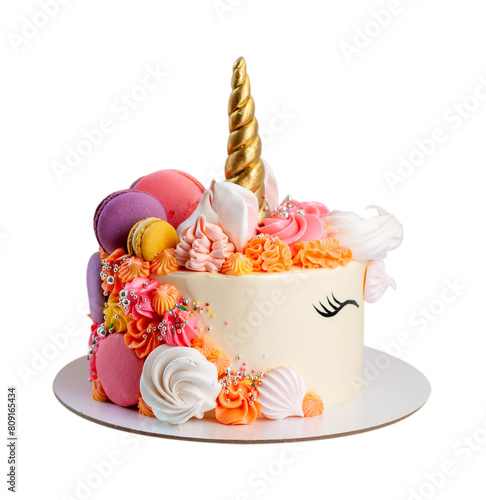 Unicorn cake with golden fondant horn, eyelashes and pink, orange, purple cream cheese frosting on neutral background