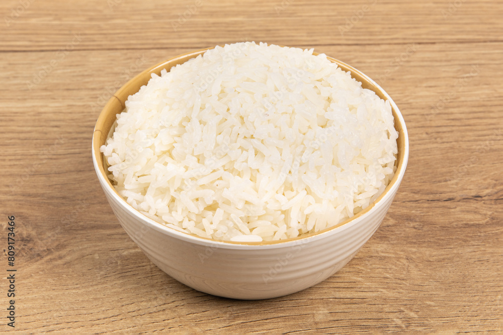 A bowl of plain white rice on a wooden table A bowl of plain white rice on a wooden table