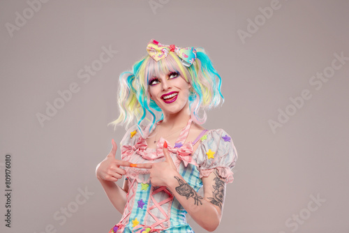 Portrait of pretty female clown in colorful outfit and hair