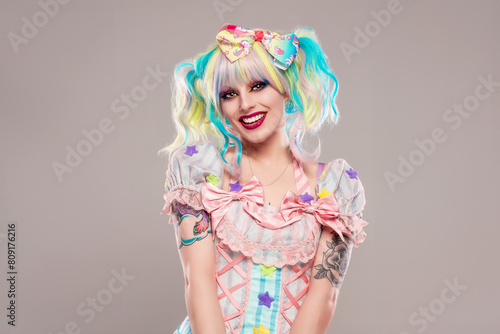 Portrait of pretty female clown in colorful outfit and hair