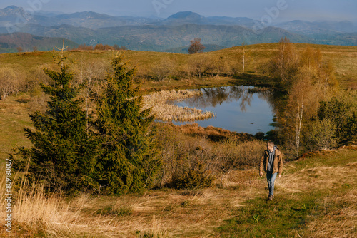 Man Hiker Walking Alone by Mountain Lake (ID: 809180007)