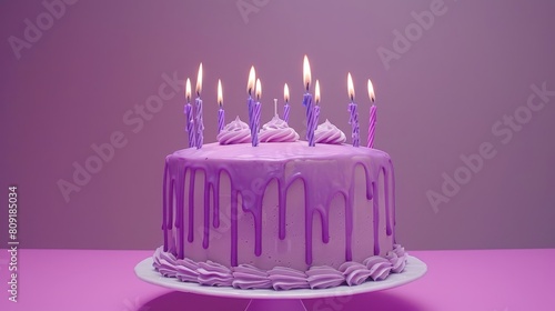   A birthday cake with purple icing and lit candles on a purple cake stand against a pink table, backed by a purple background