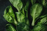 A closeup view of vibrant green bok choy leaves on a table, A close-up of vibrant green bok choy leaves against a dark background