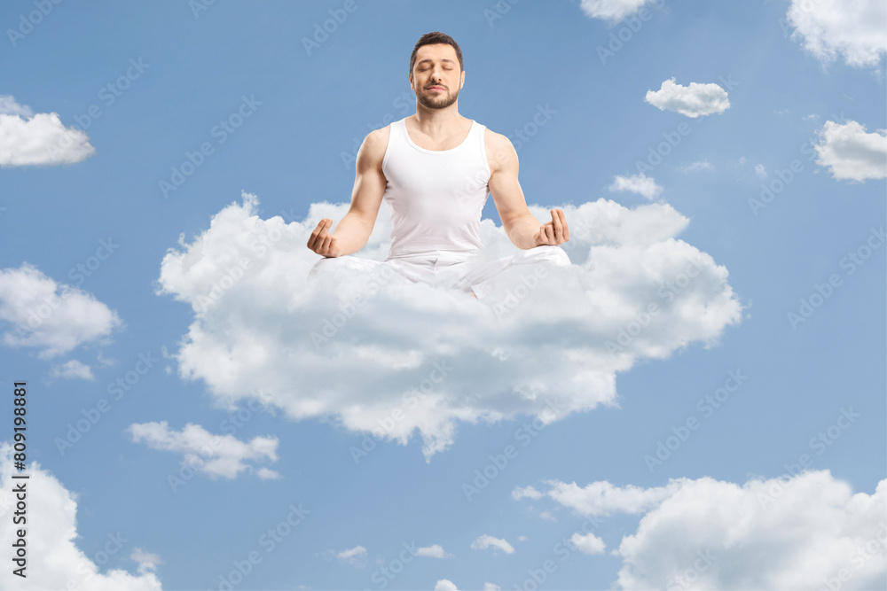 Man in white clothes meditating on a cloud Man in white clothes meditating on a cloud