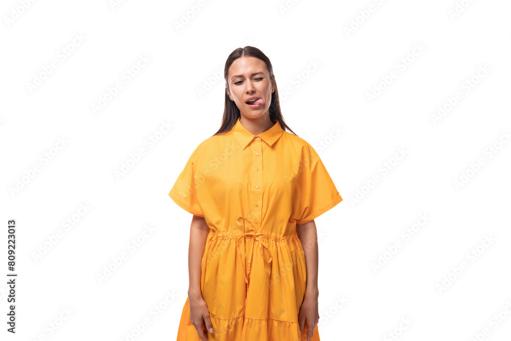 a young woman dressed in a summer yellow dress makes a grimace on a white background a young woman dressed in a summer yellow dress makes a grimace on a white background