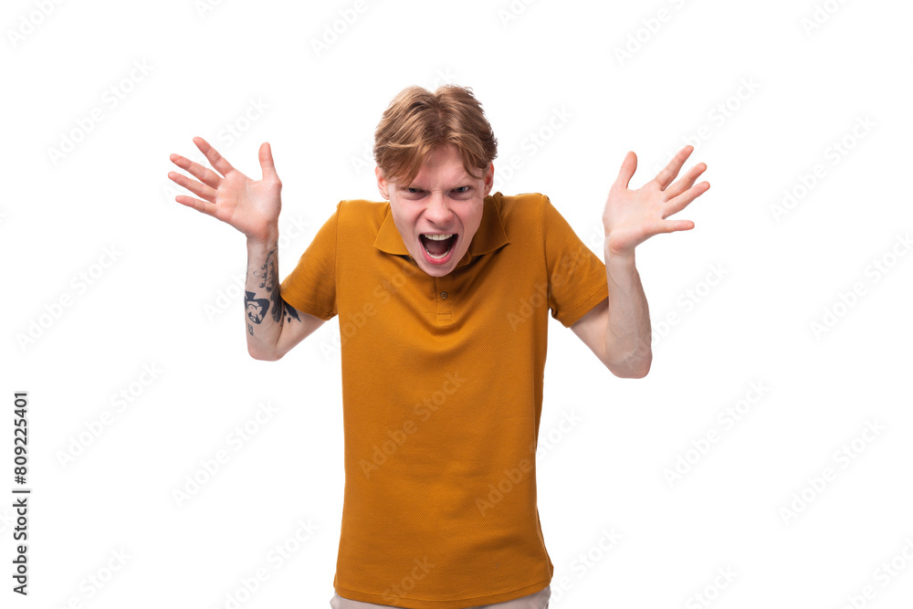 a young frustrated guy with short red hair dressed in a summer orange T-shirt is shouting with his hands up a young frustrated guy with short red hair dressed in a summer orange T-shirt is shouting with his hands up
