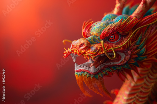 A red and gold colored dragon s head on a red background.