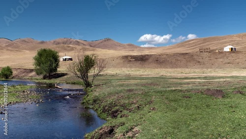 Mongolia, Tov province, panoramic view of dry steppe, 3 nomad family yurts in grassland, hill and river photo