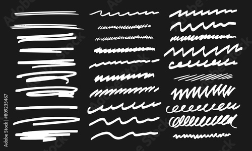 Thirty handwritten doodles. Collection of randomly drawn white squiggles on a black background
