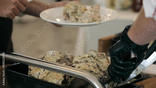 A chef slices his speciality dish. The process of slicing a large piece of baked meat. The concept of cooking and serving meat.