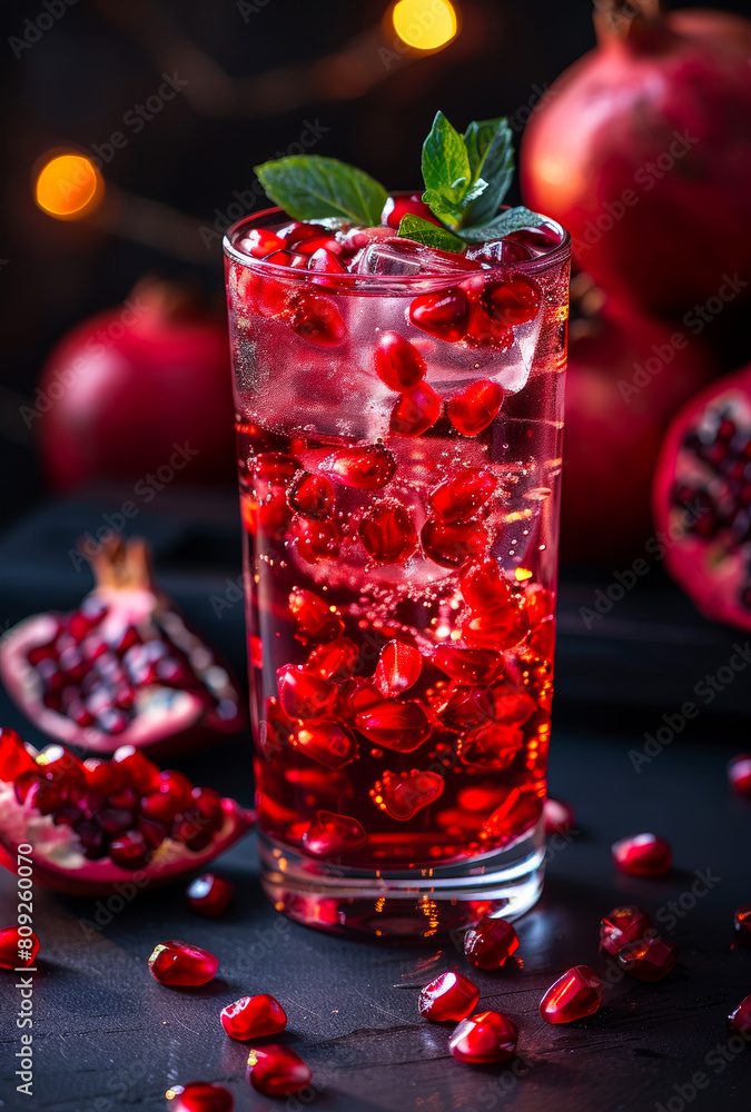 Pomegranate juice with fresh pomegranate fruits and mint on dark background Pomegranate juice with fresh pomegranate fruits and mint on dark background