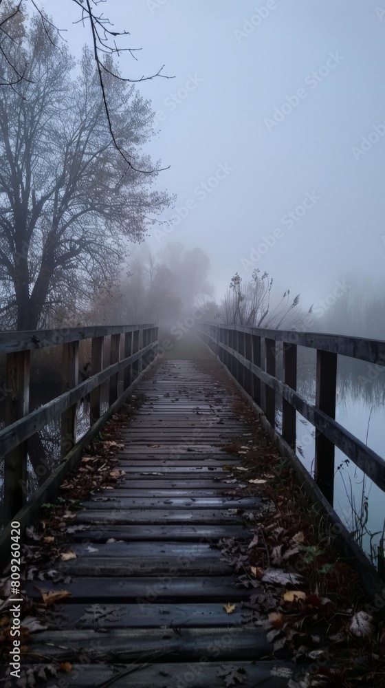 Misty morning on a wooden bridge over a tranquil river