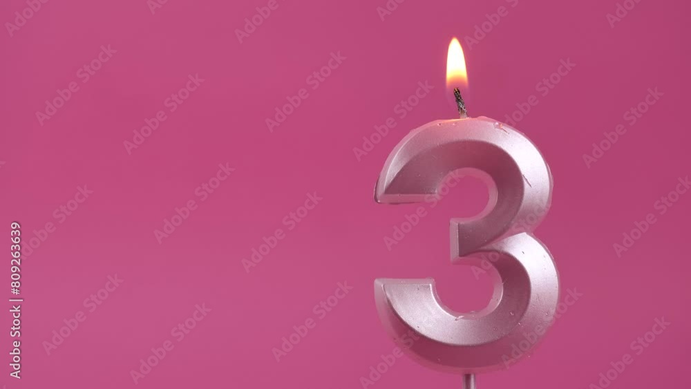 burning candle with number 3 on a pink background. Copy space. place for text. burning candle with number 3 on a pink background. Copy space. place for text.