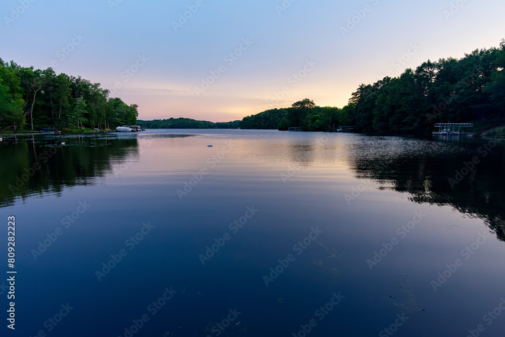 Fototapeta premium Looking onto a calm Wisconsin lake in the evening as the sun goes down.