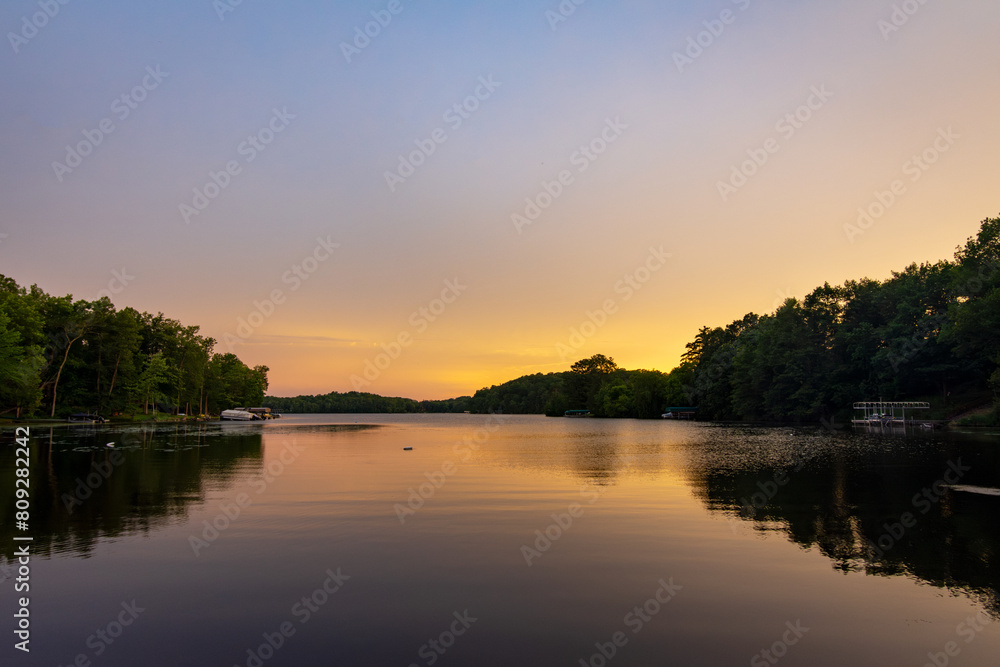 Obraz premium Looking onto a calm Wisconsin lake in the evening as the sun goes down.
