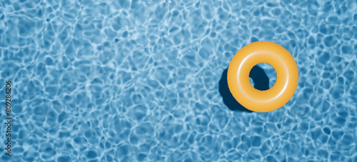 Summer holidays banner. Swimming pool top view. Yellow swimming ring in the empty clear pool. © AndS