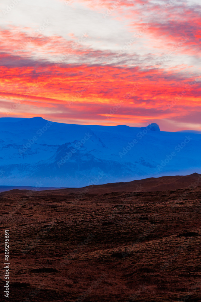 Icelandic countryside with gorgeous sunset as backdrop for night photography. Incredible view of sky becoming pink colored like cotton candy as sunlight lowers across massive northern peaks.
