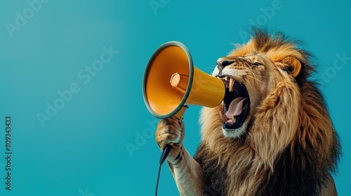 Cool beautiful lion holding and screaming into a yellow loudspeaker on a blue background. Business management and boss, a creative idea. Successful advertising and management, concept. Attention photo